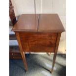 An early 20th century mahogany 'surprise' drinks table cabinet with rising top and shelf fitted with