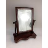 A Victorian rectangular dressing table mirror on serpentine shaped base with button feett, glass