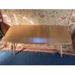 An Ercol pale wood coffee table with rounded rectangular top on splayed tapered legs with spindle