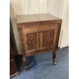 A Victorian mahogany washstand with hinged stop above tambour cupboard and drawer, on fluted