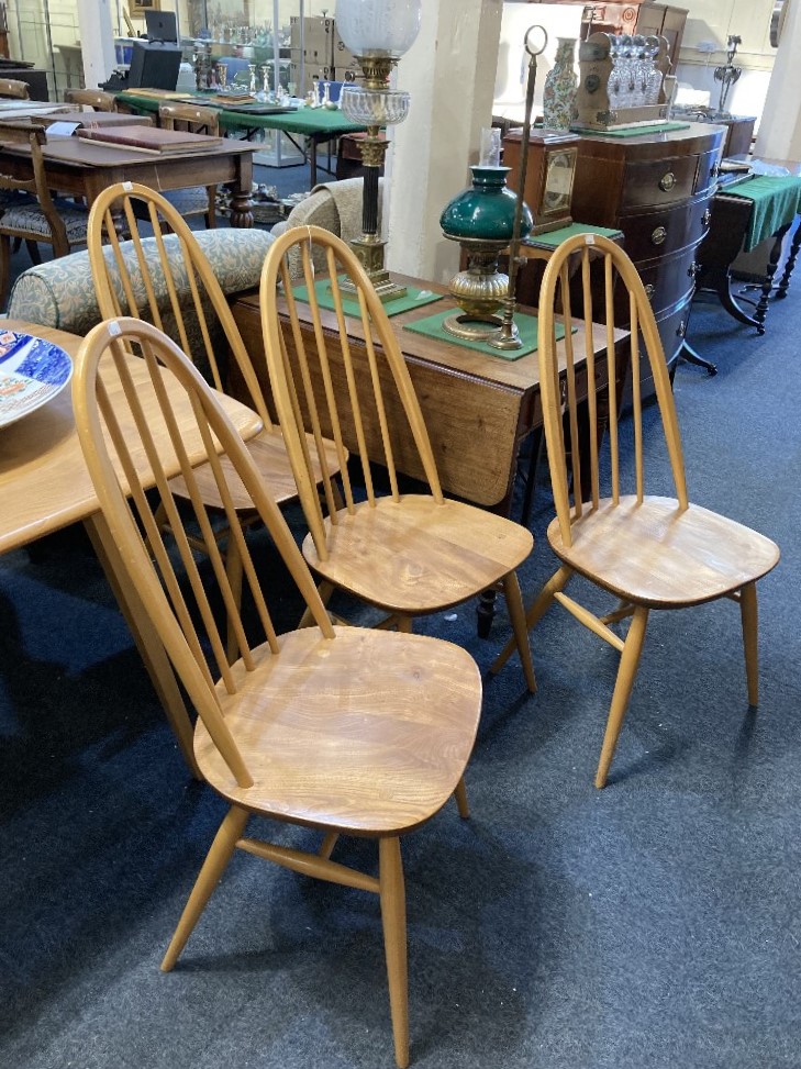 A set of Four Ercol pale wood dining chairs with hoop and stick backs on solid seats and splayed