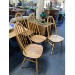 A set of Four Ercol pale wood dining chairs with hoop and stick backs on solid seats and splayed