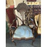 A late 19th / early 20th century carver dining chair with scroll arms and pierced back with carved