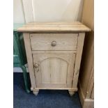 A pine bedside cupboard, with drawer above panel door enclosing two shelves, on turned feet, 51cm