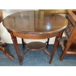 An Edwardian mahogany oval occasional table on four square tapered legs with platform stretcher on