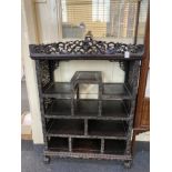 A Chinese carved hardwood display cabinet with pierced scroll gallery surmount above an