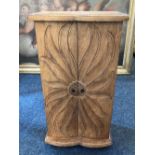 A small wooden cabinet with two doors carved with a flower 50cm high