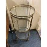 An early 20th century gilt metal three-tier cake stand with circular glass shelves and pierced