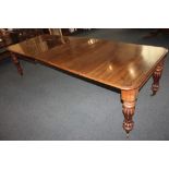 An early 19th century mahogany extending dining table, the shaped rectangular top with moulded edge,