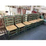 A set of six green stained ladder back dining chairs, with wicker seats
