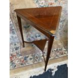 An Edwardian inlaid mahogany triangular occasional table with satinwood banded top on three square