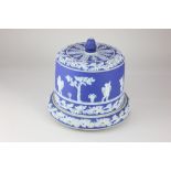 A 'Jasperware' blue and white cheese dome and stand, decorated with relief applied classical cherubs