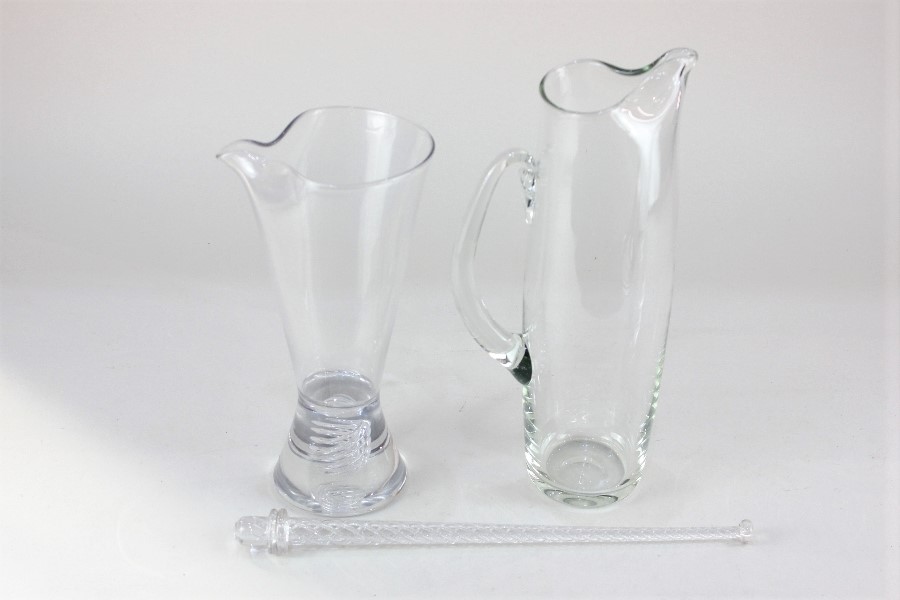 A clear studio glass jug, the heavy base with internal spring design, together with a glass