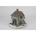 A Crown Staffordshire pastel burner formed as a cottage, on circular base, 21cm high