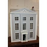 A modern Regency style three storey doll's house, with white and grey painted facade, and hinged