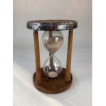 A metal bound mill bobbin hourglass sand timer, to time an hour, 23cm high