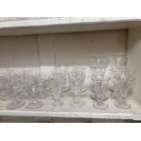 A collection of glassware to include trumpet shaped cordial glasses, etched pint glasses, a glass