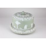 A 'Jasperware' green and white cheese dome and stand, decorated with relief applied classical