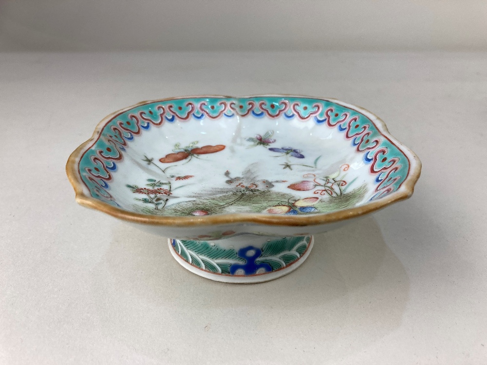 A small Chinese porcelain dish, with lobed rim, raised on a circular foot, decorated with