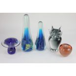 Two Mdina glass tall paperweights, tallest 26cm, together with three glass novelty paperweights,