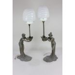 A pair of Art Nouveau style spelter table lamps, in the form of ladies holding on outstretched