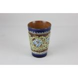 A Doulton Lambeth stoneware beaker, decorated in light relief with a border of blue flowers, birds