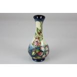 A Moorcroft pottery vase, decorated with clematis flowers on blue and cream ground, 17cm high