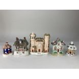 Three Staffordshire pottery cottage pastille burners, a castle, and a cottage, tallest 18cm high