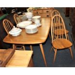 A set of six Ercol pale wood dining chairs, with hooped spindle backs and solid seats on tapered