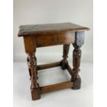 An oak joint stool with rectangular top on carved and block legs with low