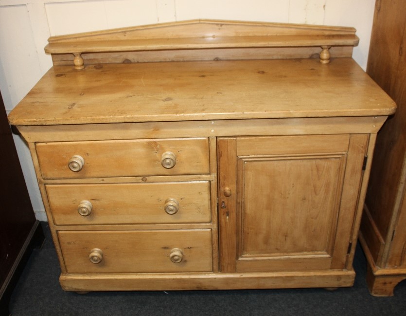 A pine sideboard, with raised shelf back, three drawers with knob handles and cupboard, on turned