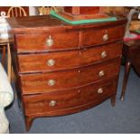 A George III mahogany bowfront chest of two short over three long drawers with circular brass drop