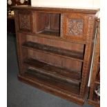 An oak open bookcase, with four shelves, the top shelf with two cupboards, carved doors and