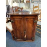 A George III oak hanging corner cabinet two panel doors with brass hinges, enclosing three shaped