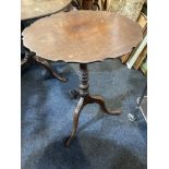 A George III mahogany circular occasional table, with serpentine border on baluster stem and