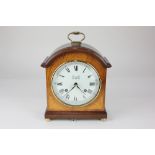 A Comitti of London reproduction mahogany mantle clock, striking on a bell, with brass carry