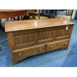 A modern oak mule chest, with carved three panel front above two drawers, on bracket feet, 112cm