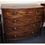 A George III mahogany bowfront chest of two short over three long drawers, with lion mask drop