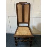 An 18th century high back chair possibly William and Mary with scroll carved top rail, later cane