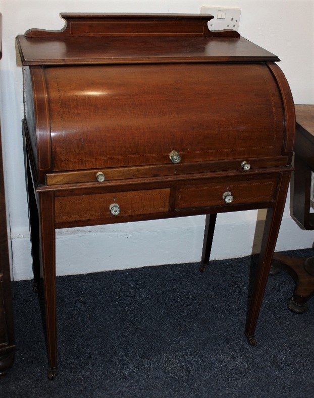 An Edwardian inlaid mahogany cylinder desk, with rising front enclosing an interior of small drawers