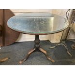 A George III oak circular tilt top tea table on baluster support and tripod base, 79cm