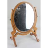 A satinwood oval adjustable dressing table mirror, on scroll supports 46cm high