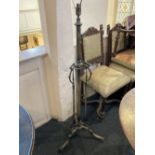 An early 20th century brass standard lamp single column with three scroll supports and tripod