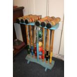 A croquet set with six mallets, six coloured balls and eleven metal hoops, on painted blue wooden