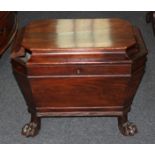 A Regency mahogany wine cooler, sarcophagus shape, with rising top, lion mask ring handles, on
