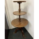 A 19th century mahogany three tier dumb waiter with three circular shelves on turned baluster