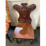 A Victorian hall chair with scroll carved shield shaped back, solid seat, on tapered legs