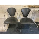 A pair of modern chrome metal framed chairs with black triangular shaped backs and seats,