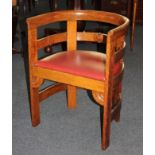 An Arts & Crafts oak tub chair in the manner of Liberty & Co, with carved stylized motifs, and