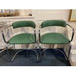 A pair of modern chrome metal framed chairs with green moire fabric padded backs and seats on